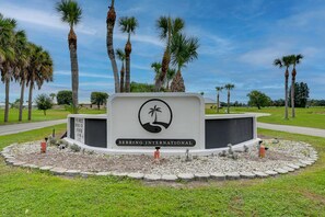 Une enseigne indiquant l’entrée de Sebring International, avec des palmiers et un ciel dégagé en arrière-plan.