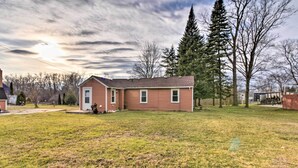 A single-story house with a front porch, a small yard, and a large tree to the right. - Completely Renovated Escape ~ 1 Mile to Downtown! (Farmington Hills)