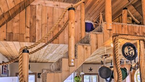 A wooden interior with a spiral staircase, wooden beams, and hanging pots. - Serenity at Scenic Bay: Floating Cottage w/ Views! (Bayview)