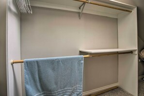 Een badkamer met een handdoekhouder, een plank en een handdoek aan de houder.