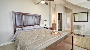 A bedroom with a bed, a wooden nightstand, a coffee tray, a chair, and a ceiling fan. - Pasco Condo w/ Columbia River Views + Hot Tub (Pasco)