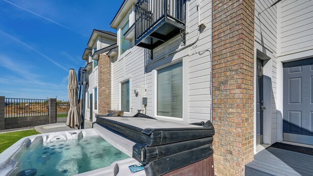 A residential property with a hot tub, a covered patio, and a brick exterior. - Pasco Condo w/ Columbia River Views + Hot Tub (Pasco)