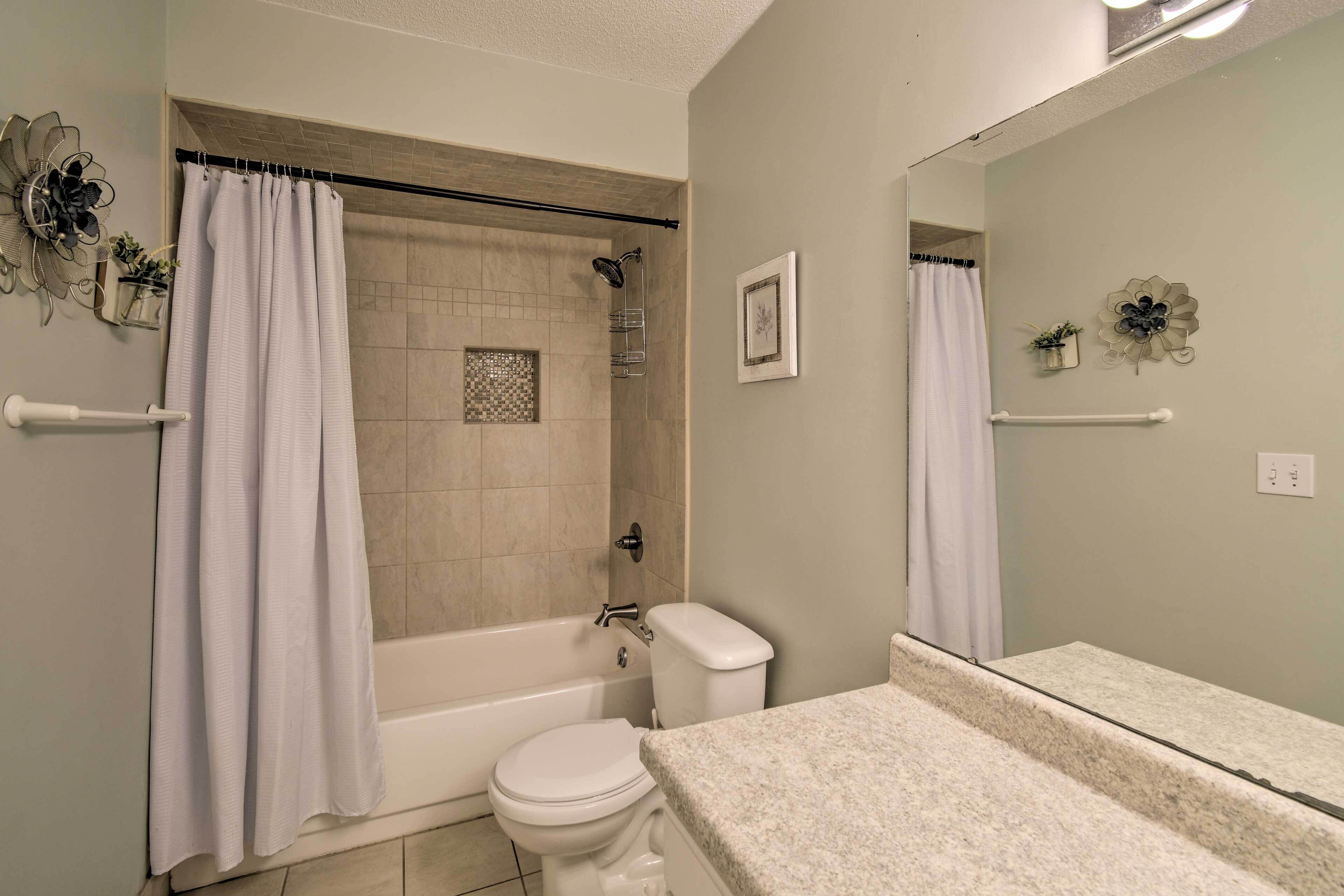 A bathroom with a shower, toilet, and sink.