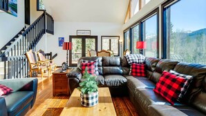 Ein geräumiges Wohnzimmer mit einer Ledersofa, einem Holztisch und einer Treppe.
