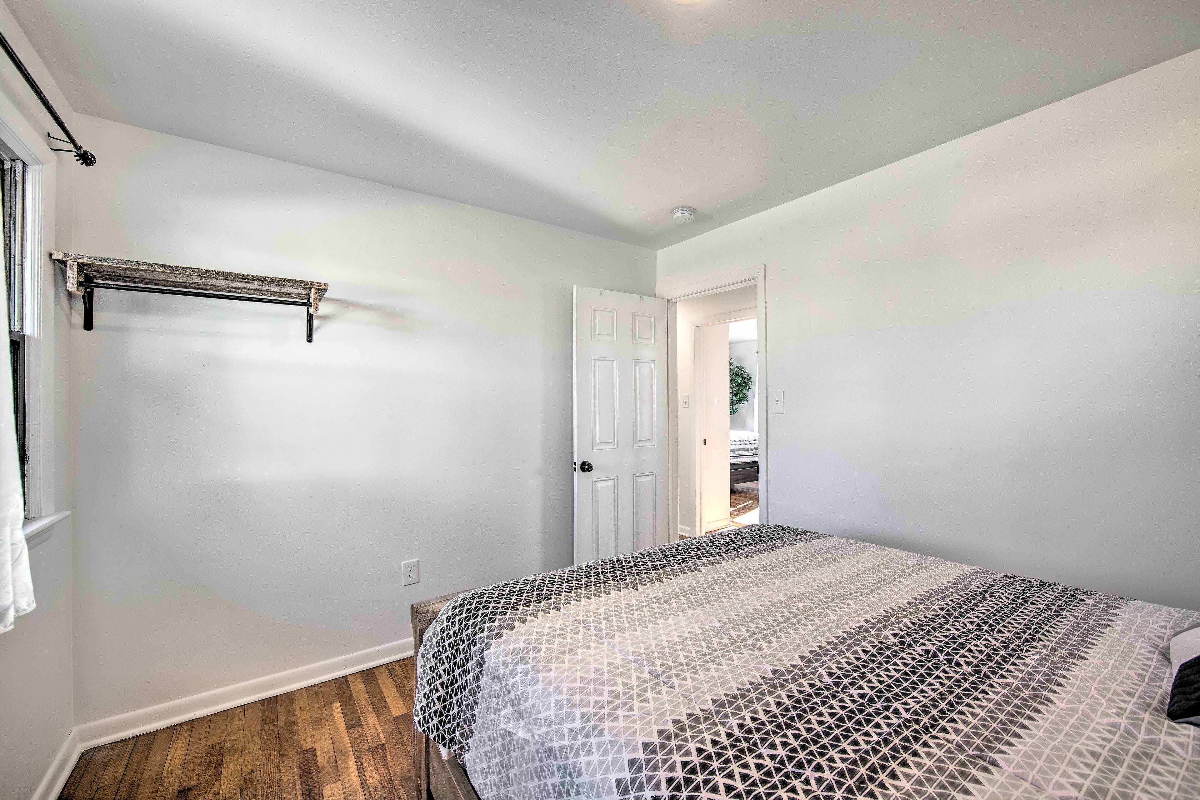 A bedroom with a bed, a door, and a window.