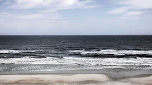 A beach with waves and a clear sky.
