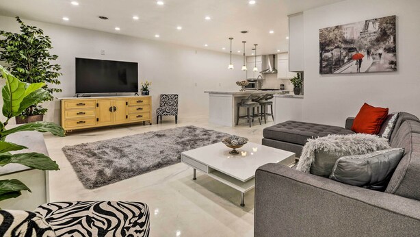 A modern living room with a flat-screen TV, grey sofa, and a coffee table. - Renovated Griffith Family Home in Chicagoland Area (Griffith)