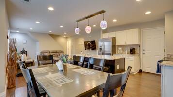 A modern kitchen with a central island, recessed lighting, and pendant lights.