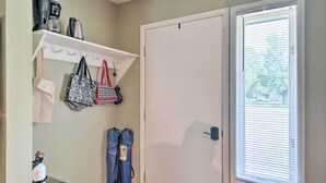 A room with a white door, a window with blinds, a shelf with bags and a coffee maker. - Townhome w/ Fireplace - Walk to Chairlift! (Ellicottville)