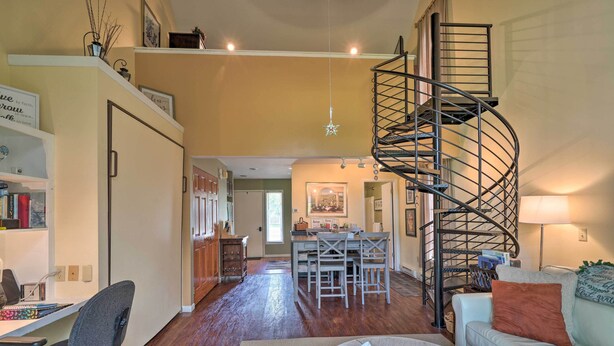 A spacious living room with a spiral staircase, a dining area, and a cozy seating area. - Townhome w/ Fireplace - Walk to Chairlift! (Ellicottville)