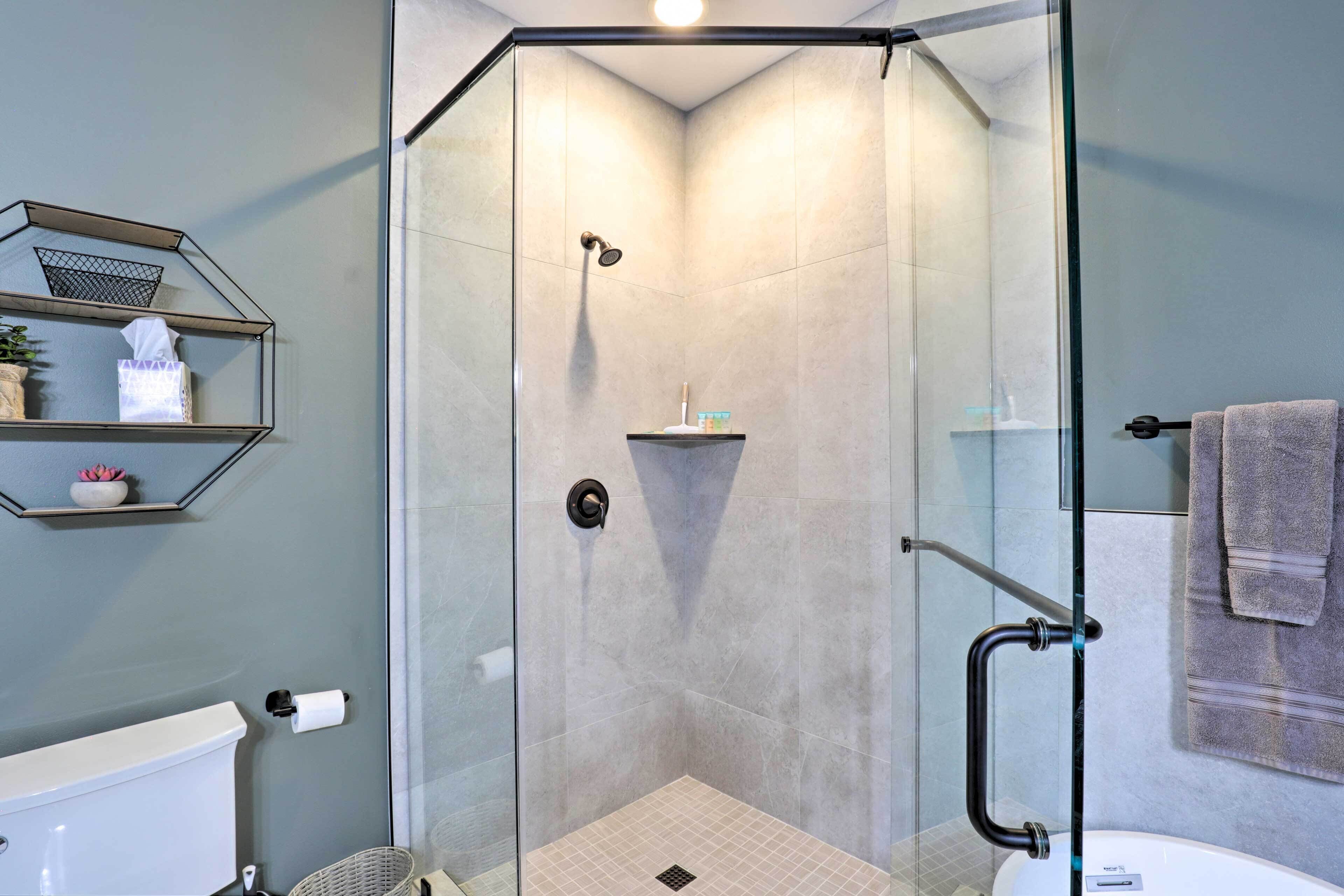 Een moderne badkamer met een douchecabine, toilet en wastafel.