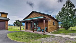 A wooden cabin with a porch and outdoor seating. - Cabin w/ Porch & View ~ 19 Mi to West Glacier (Columbia Falls)