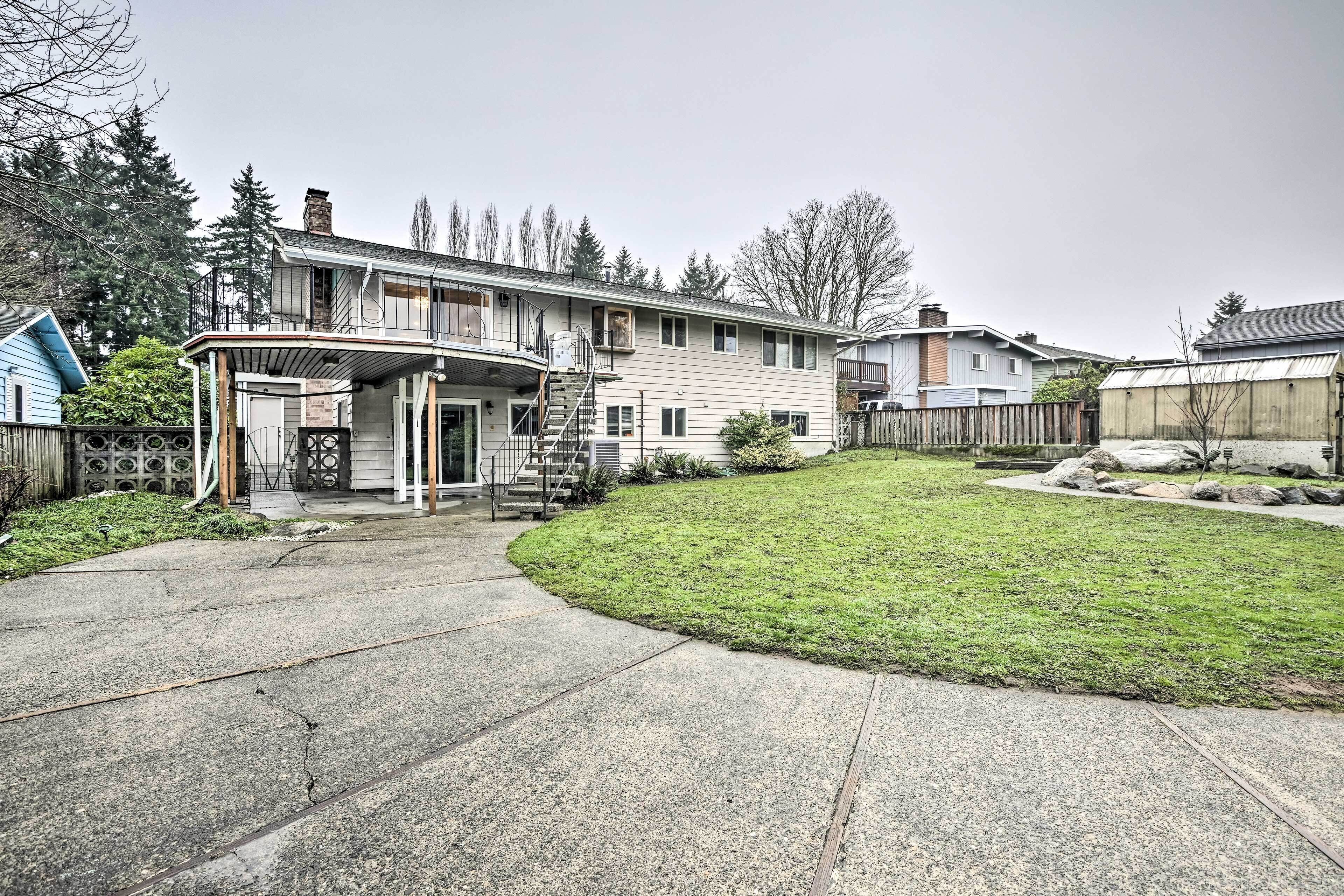 A two-story house with a covered porch, a small front yard, and a wooden fence.