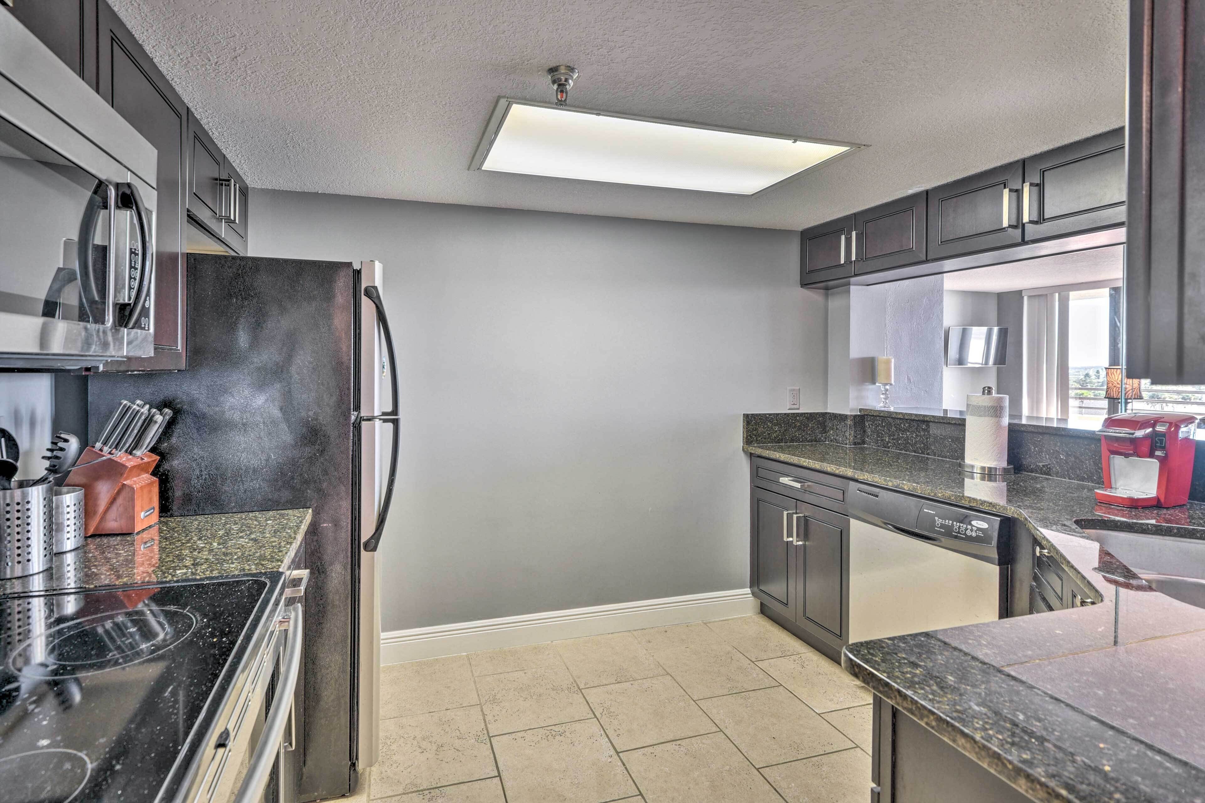 Una cocina moderna con un refrigerador de acero inoxidable, un microondas y un lavavajillas.