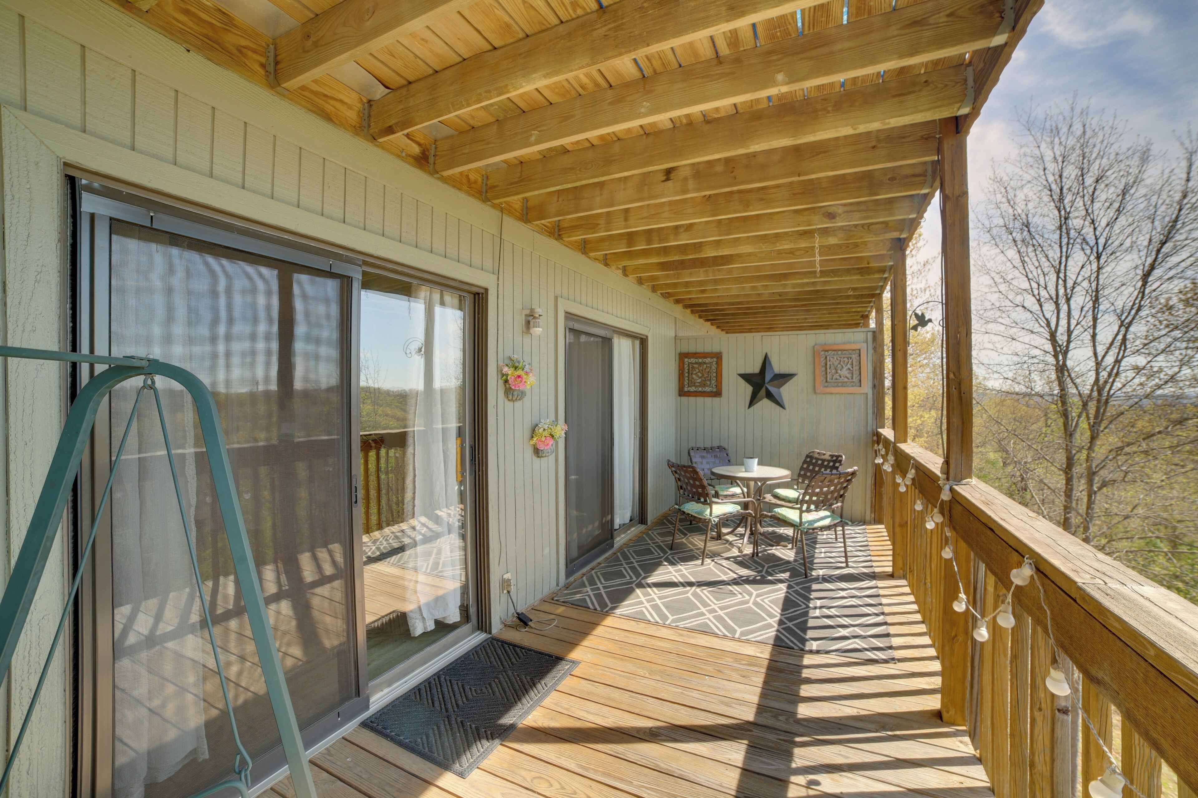 A wooden deck with a table and chairs, a star decoration, and a view of the outdoors.