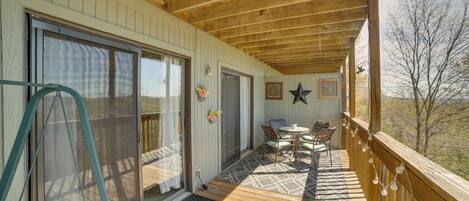A wooden deck with a table and chairs, a star decoration, and a view of the outdoors.