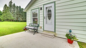 A house with a front porch, a bench, and a potted plant. - Visit Fife Lake & Traverse Bay! Farmhouse Hideaway (Fife Lake)