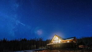 A cabin with a large balcony, surrounded by a forest and snow-covered ground. - 5 Acres of Scenic Beauty! Large Fairplay Log Home (Fairplay)