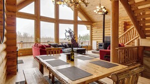 A log cabin interior with a large dining table, sofas, a fireplace, and a staircase. - 5 Acres of Scenic Beauty! Large Fairplay Log Home (Fairplay)