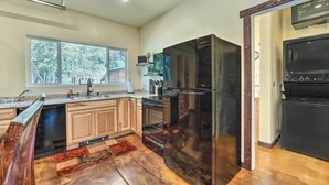 A modern kitchen with wooden cabinets, a black refrigerator, and a dishwasher. - Serene Dolores Cabin w/ Patio & River Access! (Dolores)