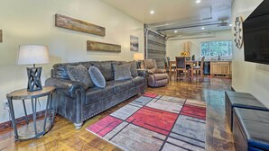 A living room with a leather sofa, a coffee table, a rug, and a ceiling fan. - Serene Dolores Cabin w/ Patio & River Access! (Dolores)