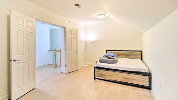 Ein Schlafzimmer mit Bett, Tür und Flur.