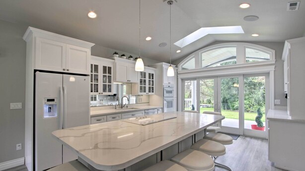 A modern kitchen with a large island, white cabinetry, and a view of the outdoors. - Contemporary Tacoma Cottage w/ Deck & Pond! (Tacoma)