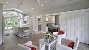 A spacious living area with a kitchen, dining area, and a bedroom with a large window. - Contemporary Tacoma Cottage w/ Deck & Pond! (Tacoma)