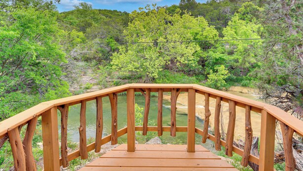 A wooden deck with a railing overlooking a natural landscape. - Cedar Falls Cabin: Nestled by Honey Creek (Davis)
