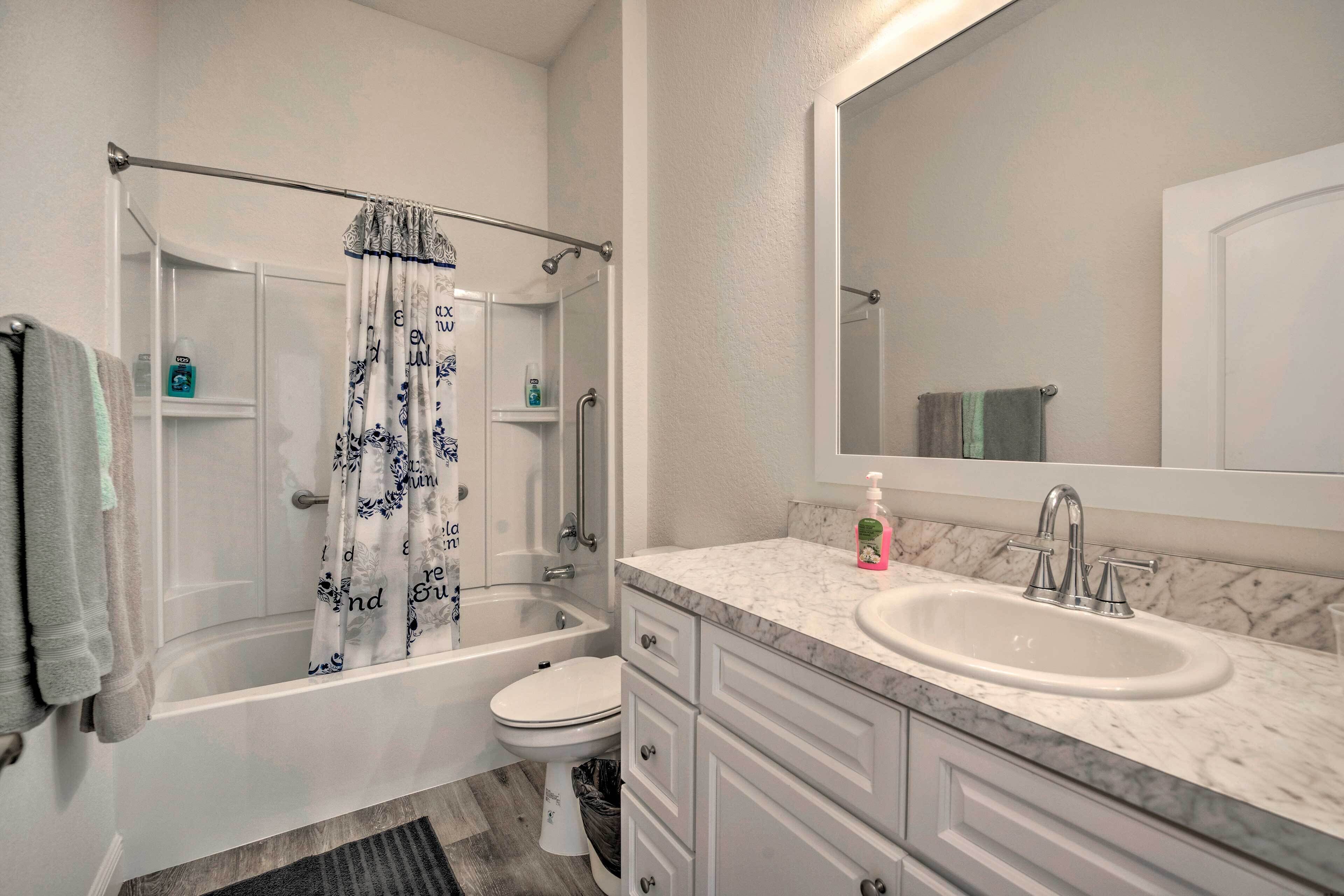 A bathroom with a bathtub, toilet, and sink.