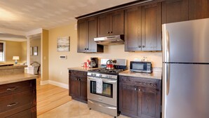 A kitchen with dark wooden cabinets, stainless steel appliances, and a tiled floor. - Finger Lakes Retreat: 3 Mi to Seneca & Keuka Lake (Himrod)
