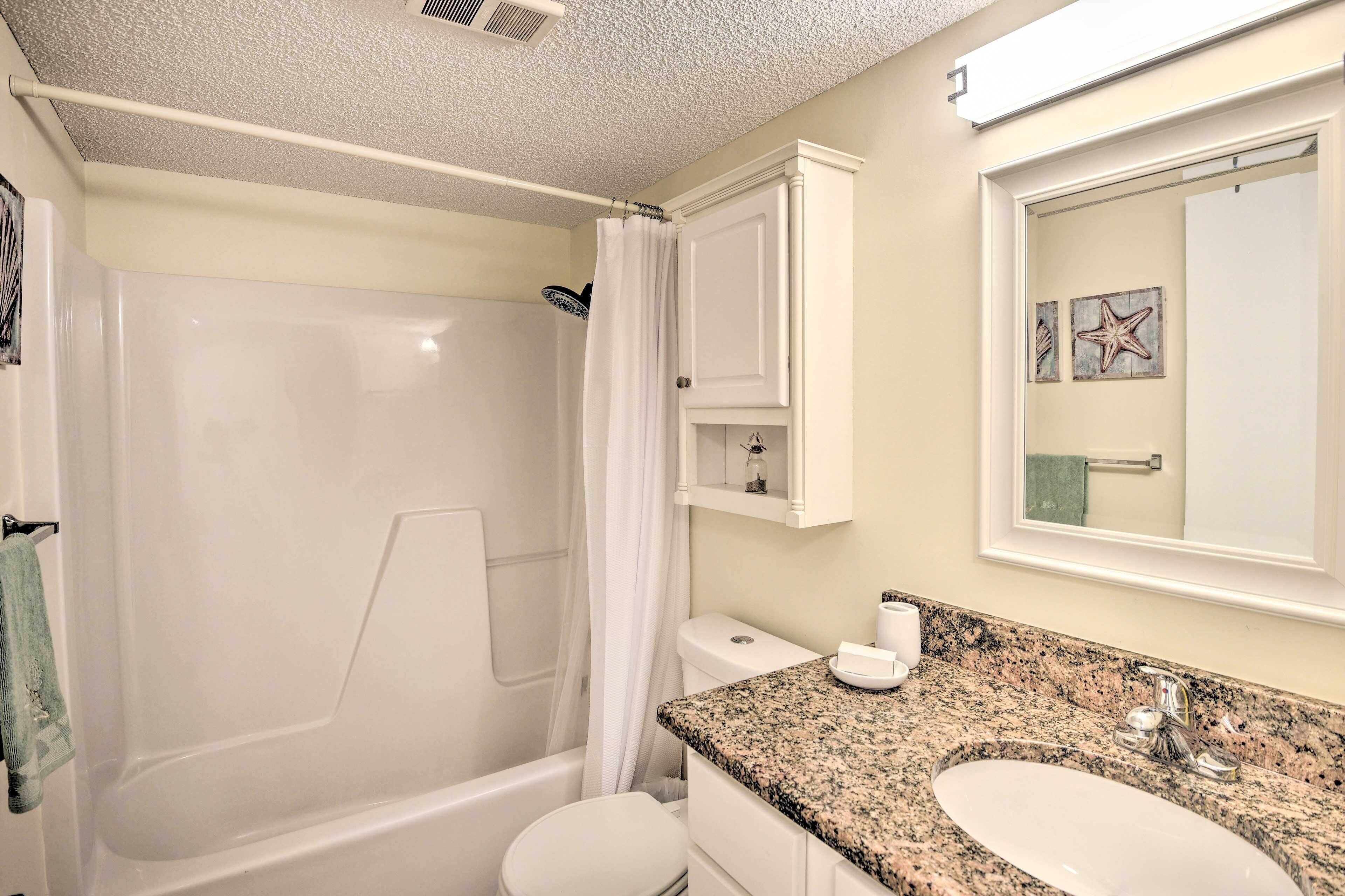 Un baño con bañera, inodoro y lavamanos.