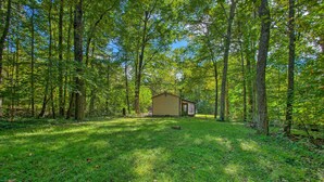 A small cabin in a forest with a grassy clearing. - Quaint Hinton Hideaway - Hunt & Fish Nearby! (Hinton)