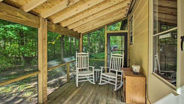 A wooden deck with two rocking chairs and a small table, overlooking a forested area. - Quaint Hinton Hideaway - Hunt & Fish Nearby! (Hinton)