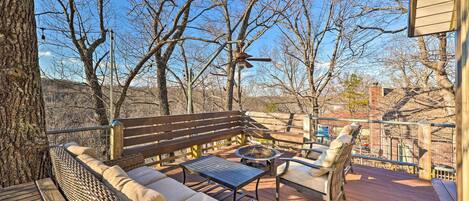 A deck with a sofa, chairs, and a fire pit.
