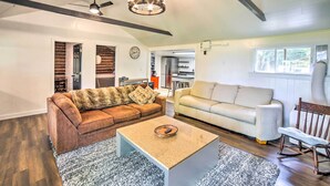 A spacious living room with two sofas, a coffee table, and a dining area with a chair. - Crivitz Lakefront Escape w/ Boat Dock & Slip! (Crivitz)