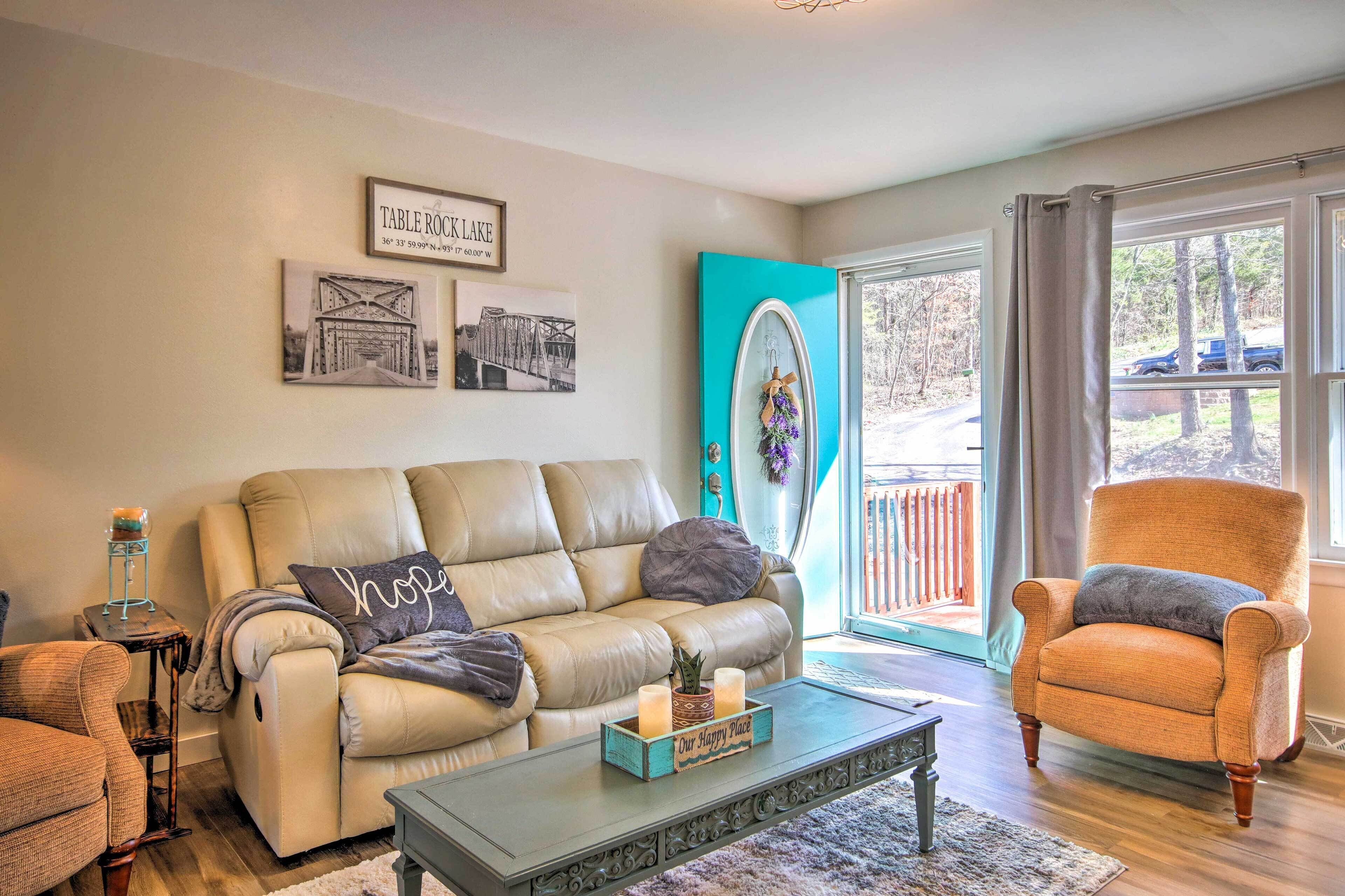A living room with a beige sofa, a wooden coffee table, and a teal accent wall.