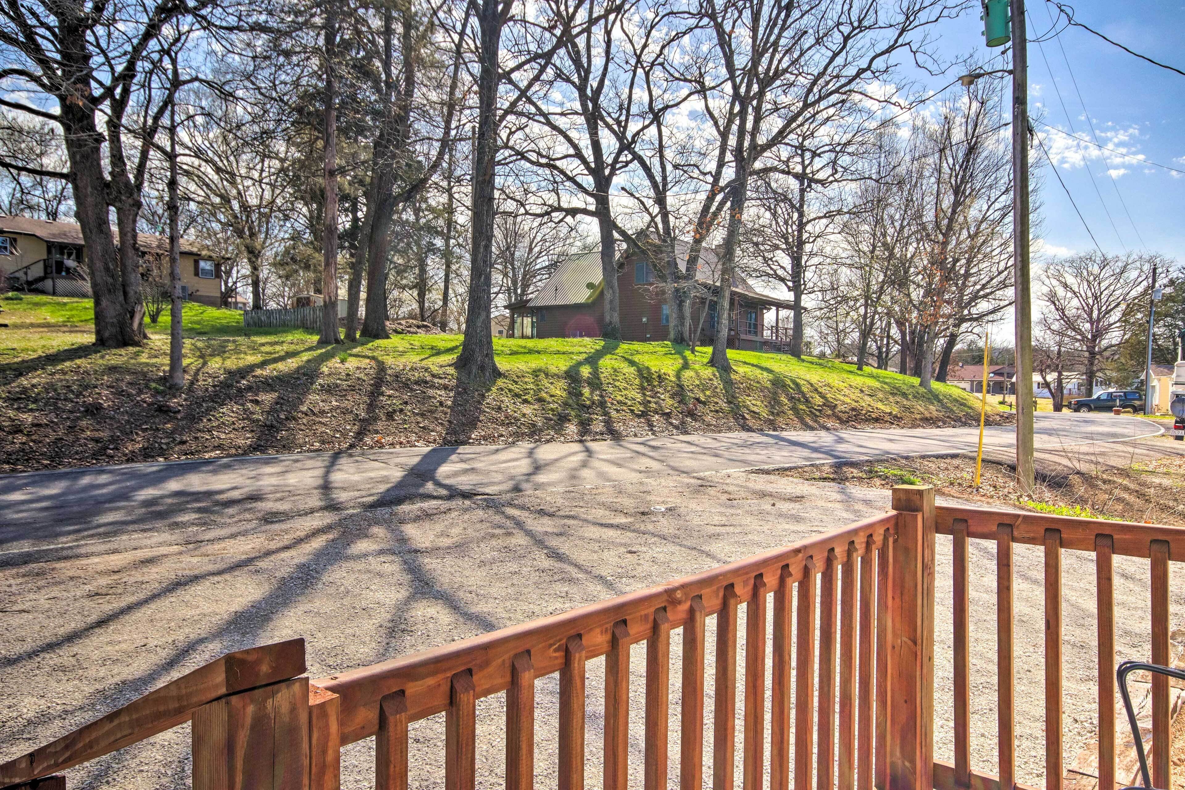 A residential area with a house, trees, and a road.