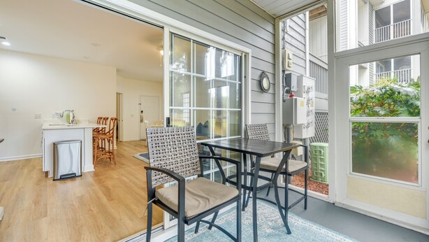 A modern kitchen with a white countertop and wooden chairs. - Sunset Beach Retreat - Monthly Rentals Welcome! (Sunset Beach)
