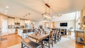A spacious kitchen with modern appliances, a dining area with a large wooden table and chairs, and a cozy living room with a television and seating. - Lake Anna Home w/ Dock & Private Shoreline! (Bumpass)
