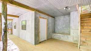 Ein Zimmer mit Holzboden, weißer Tür und Fenster.