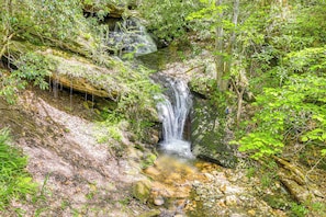 Una cascada natural rodeada de vegetación exuberante.