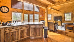 L’intérieur de la cabine est en bois, il comprend un espace cuisine avec un grand îlot central, un coin salon avec un téléviseur et de grandes fenêtres.