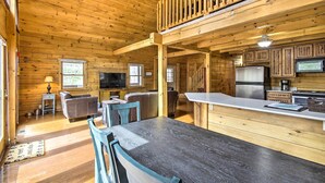 L’intérieur d’une cabane en bois comprend un coin repas, une cuisine et un salon.
