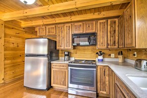 A kitchen with wooden cabinets, a stainless steel refrigerator, a microwave, a stove, and a toaster. - Cozy Winter Retreat: Great Location & Pet Friendly (New Market)