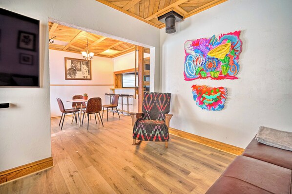 A spacious living area with a wooden floor, a patterned armchair, and a vibrant abstract painting on the wall. - Cozy House: Walk to Park City Mountain Lifts! (Park City)