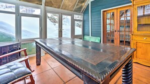 Um quarto com uma mesa grande, um armário de madeira e um banco.