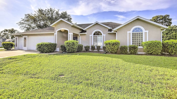 A two-story house with a well-maintained lawn, a garage, and a driveway. - Ocala Gem: 5 Mi to World Equestrian Center! (Ocala)