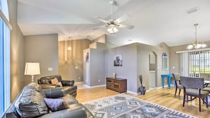 A spacious living room with a leather sofa, a patterned rug, a dining area with a table and chairs, and a ceiling fan. - Ocala Gem: 5 Mi to World Equestrian Center! (Ocala)