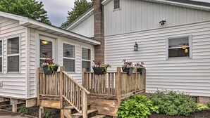 A white house with a wooden porch and potted plants. - Cozy Seneca Falls Home Close to Cayuga Wine Trail! (Seneca Falls)